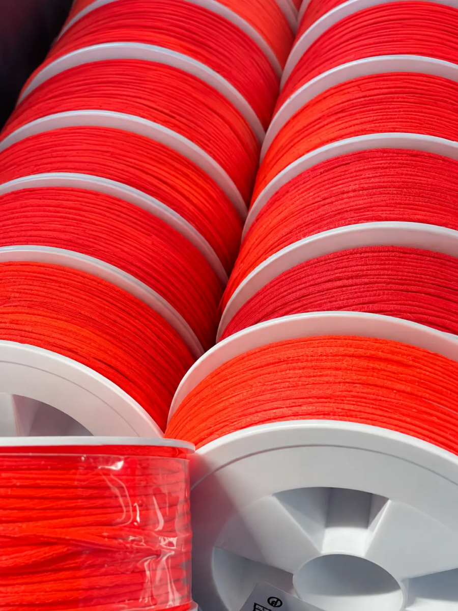 Bobines de cordon orange vif alignées — Maison Satab