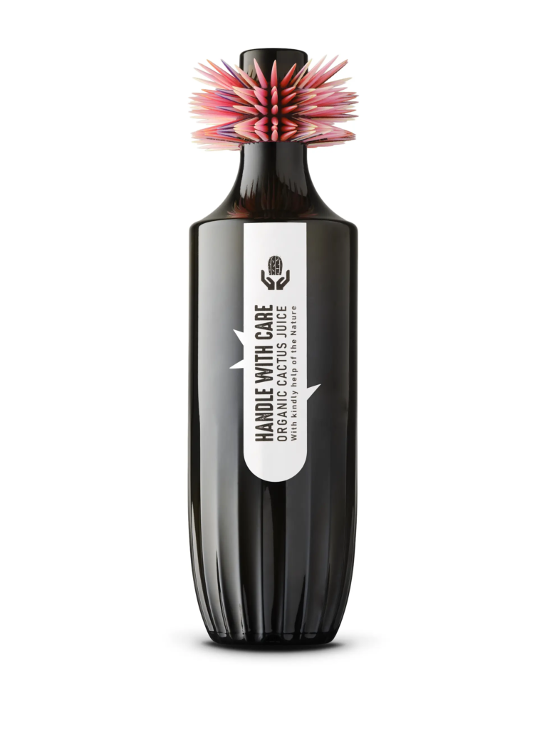 Bouteille Organic Cactus Juice à bouchon hérissé de fibres roses, habillée d’une étiquette « Handle with care » — Maison Satab