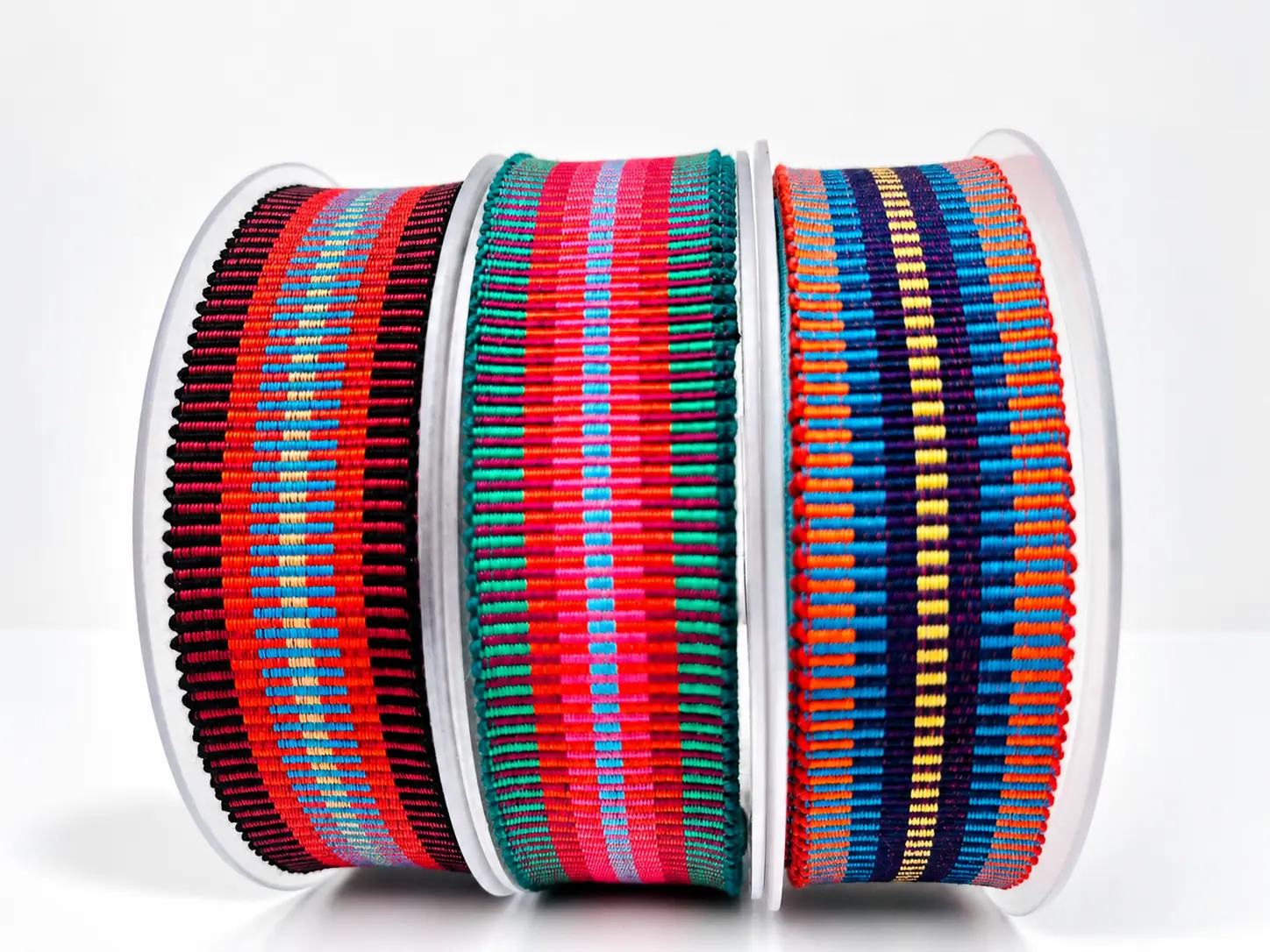 Trois bobines de galons rayés multicolores, dominantes rouge, vert et bleu — Maison Satab